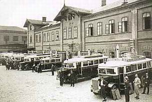 Historical photo of public transport buses in front of the train station in 1930