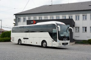 Autobus zájezdové dopravy před budovou dispečinku, přední pohled