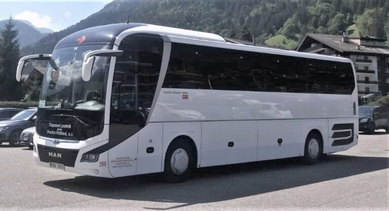 MAN R07 tour bus parked at a mountain resort in the summer.