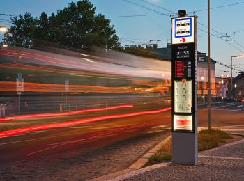 Podvečerní fotografie rozsvíceného označníku na zastávce Muzeum